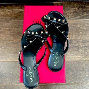 VALENTINO GARAVANI PVC flip flops. Bow detailing with platinum-finish studs.